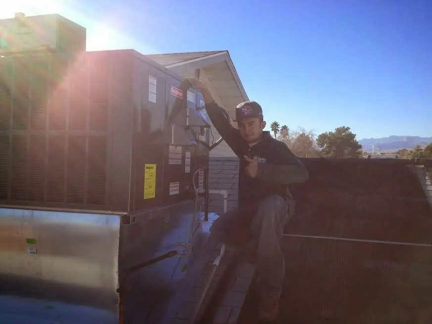 HVAC technician performing Air Duct Repair on a rooftop unit in Rancho Santa Margarita
